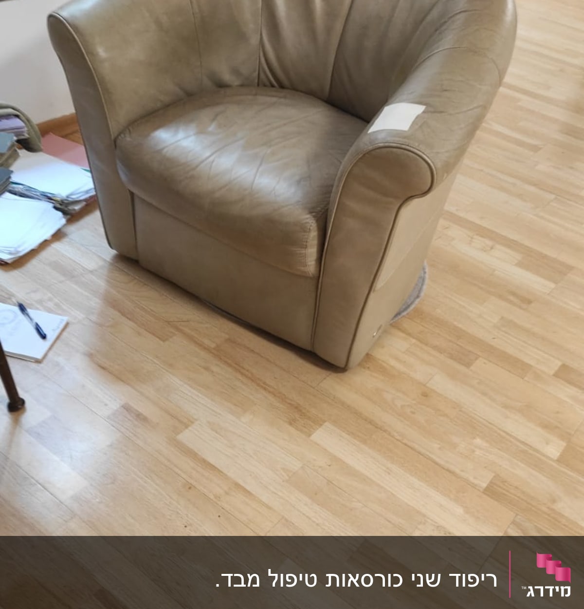 כורסה מרופדת מעור עם תיקון על הידית